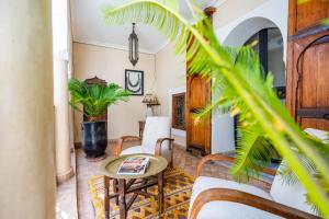 a living room with a table and chairs at Riad El Youssoufi in Marrakesh