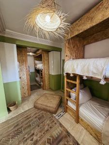 Pokój z 2 łóżkami piętrowymi i żyrandolem w obiekcie Tazuri Surf House w mieście Taghazout