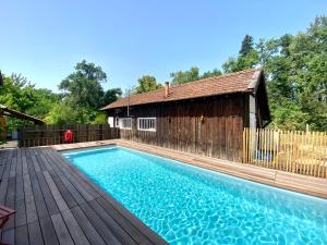 a swimming pool with a wooden deck and a building at Authentique villa du XIX e siècle avec piscine in Lue +14 photos