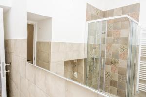 a bathroom with a shower with a mirror at Mille Lire - Family suites in Monopoli