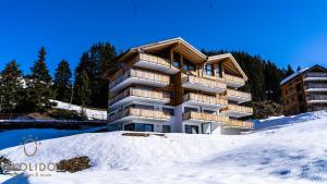 a apartment building in the snow in the mountains at Haus Golmenegg, Riederalp in Riederalp