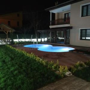 ein großer blauer Pool vor einem Haus in der Nacht in der Unterkunft Villa manolya in Sapanca
