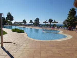 a swimming pool at a resort with a beach at Apartamentos Mar Blau in Son Bou