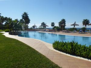 a swimming pool at a resort with palm trees at Apartamentos Mar Blau in Son Bou