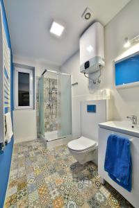 a bathroom with a toilet and a shower and a sink at Apartamenty KOMBI in Nowy Targ