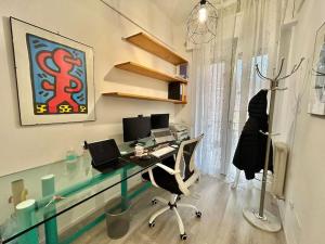 um escritório com uma secretária de vidro com um computador em Appartamento Moderno al Centro di Spoleto em Spoleto