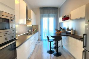 uma cozinha com armários brancos e uma mesa em Appartamento Moderno al Centro di Spoleto em Spoleto