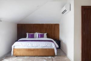 a bedroom with a large bed with purple pillows at Aapartments in Abuja