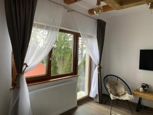 ein Fenster mit Vorhängen und einem Stuhl in einem Zimmer in der Unterkunft Tiarra Mountain Lodge in Beliş