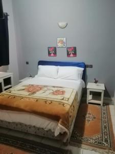 ein Schlafzimmer mit einem Bett und zwei Tischen in der Unterkunft HOTEL ERRACHIDIA in Er Rachidia