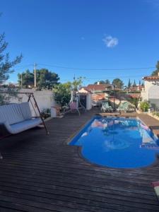 a swimming pool on a deck with a couch next to it at VILLA MIAMI in Miami Platja