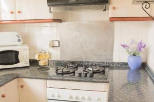 a kitchen with a stove and a microwave at VILLA MIAMI in Miami Platja
