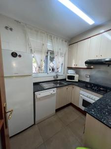 a kitchen with white cabinets and a white refrigerator at VILLA MIAMI in Miami Platja