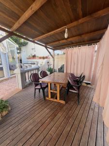 a wooden deck with a wooden table and chairs at VILLA MIAMI in Miami Platja