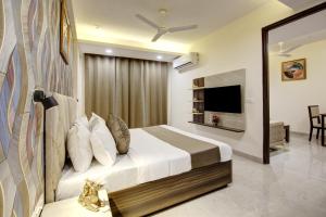 a hotel room with a bed and a television at Limewood Stay Golf Course Road in Gurgaon