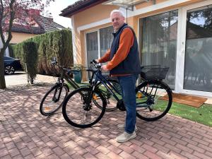 mężczyzna stoi obok roweru w obiekcie Serenity Garden Villas - Polanica-Zdrój 