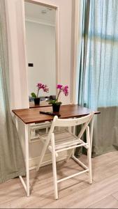 a dressing table with a mirror and flowers on it at Guest&Rest 11 in London