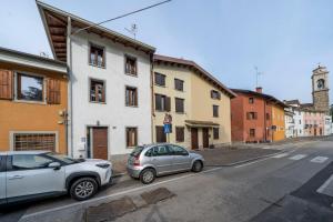 dois carros estacionados ao lado de um edifício numa rua em Jacaranda em Udine