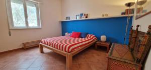 1 dormitorio con 1 cama con rayas rojas y blancas en La Casa di Azul en Levanzo