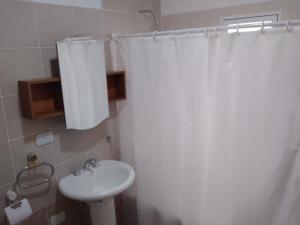 bagno con tenda da doccia bianca e lavandino di Casa Stegmann a Pringles