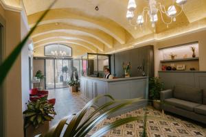 a lobby with a woman at a counter at IBB Hotel Palazzo Bettina Malta in Birgu