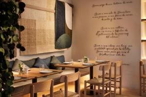 a restaurant with wooden tables and chairs and a wall with writing at NH Madrid Zurbano in Madrid