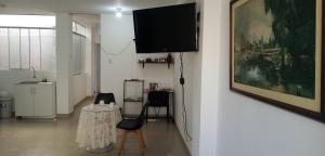 un soggiorno con TV, tavolo e sedie di Alojamiento del Norte a Chiclayo