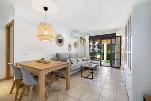 ein Wohnzimmer mit Tisch und Couch in der Unterkunft Apartamento en Playa de La Barrosa in Chiclana de la Frontera
