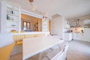 a kitchen and dining room with a white table and chairs at ApartmentsGarda - Residence Pasola in Brenzone sul Garda