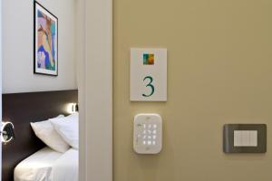 a room with a bed and a remote control on the wall at Palm Suites in Naples