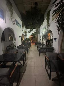 un restaurante vacío con mesas, sillas y plantas en Devran Pansiyon, en Bodrum City