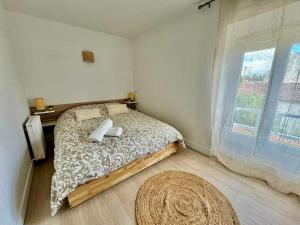 een slaapkamer met een bed en een groot raam bij Chez Thony et Laeti Maison de village proche Disney in Villiers-sur-Morin