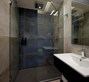 a bathroom with a sink and a glass shower at Palm Suites in Naples +29 photos