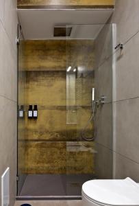 a bathroom with a glass shower with a toilet at Palm Suites in Naples