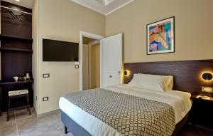 a bedroom with a bed and a flat screen tv at Palm Suites in Naples