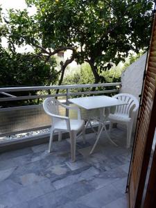 a white table and two chairs on a balcony at Ntaskas apartments in Poulithra +23 photos