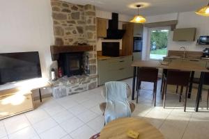 a kitchen with a living room with a stone fireplace at Gîte le 7 de Coeur, Baie Mont St Michel in Dragey +27 photos