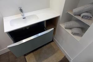 a white bathroom with a sink and towels at Gîte le 7 de Coeur, Baie Mont St Michel in Dragey