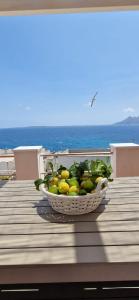 a basket of limes sitting on a deck with the ocean at La Casa di Azul in Levanzo