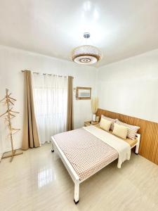 a bedroom with a bed and a chandelier at Olongapo Lawud - 3mins Walking Distance to Inflatable Island and Beaches in Olongapo