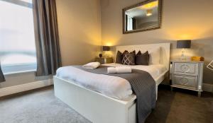 a bedroom with a bed with a mirror on the wall at Central - Business Stays - Relocating in Harrogate