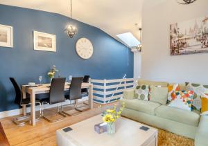 a living room with a table and a blue wall at The Old Mill Cottage - Norfolk in Fakenham