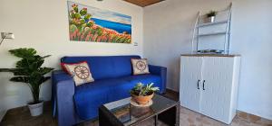 sala de estar con sofá azul y mesa en La Piccola Perla di Ortigia en Siracusa