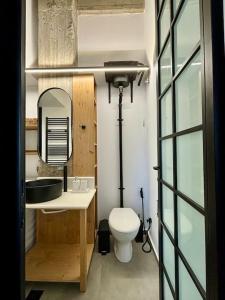 La salle de bains est pourvue de toilettes, d'un lavabo et d'un miroir. dans l'établissement Industrial Loft Comfort Living, à Héraklion