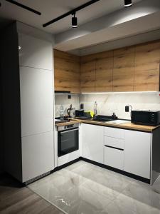 a kitchen with white appliances and wooden cabinets at A-Brilliant, NEW! spacious & modern apartment in Varna whit GARAGE in Varna City