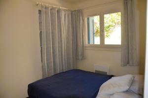 1 dormitorio con cama y ventana en GRILAF - Au cœur du village typique de Grimaud appartement coquet, en Grimaud