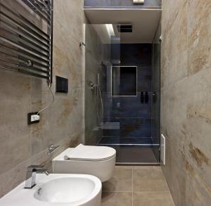 a bathroom with a toilet and a shower and a sink at Palm Suites in Naples