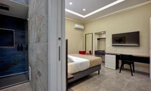 a bedroom with a bed and a desk and a television at Palm Suites in Naples
