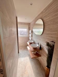 un bagno con due lavandini e uno specchio di Villa privée 230m2/ Piscine débordement/Billard-Babyfoot-Boulodrome-Flipper/Strasbourg a Dettwiller