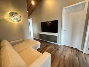 een woonkamer met een bank en een flatscreen-tv bij Holiday Home in Húsafell
